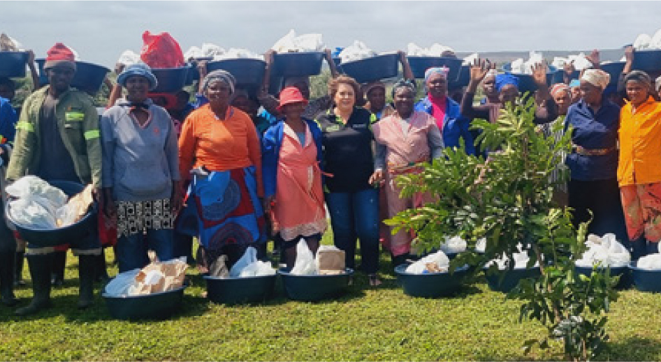 A group standing outdoors beside containers and packaged supplies.